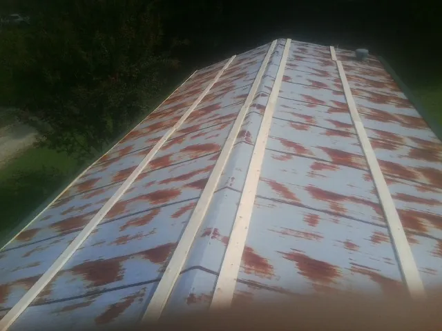 Rusted metal roof panels with new wood purlins before replacement — Storm Damage Roof Repair in Gilbertsville by Roofing Brothers