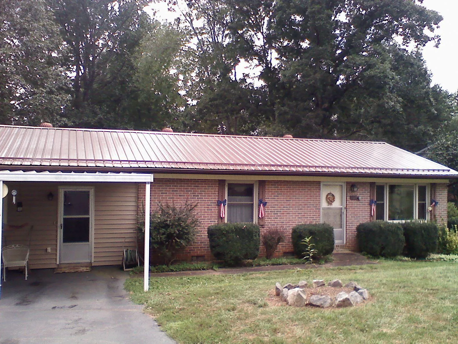 Bronze metal roof and carport on a brick ranch home — Roof Repair work by our crew in Gilbertsville
